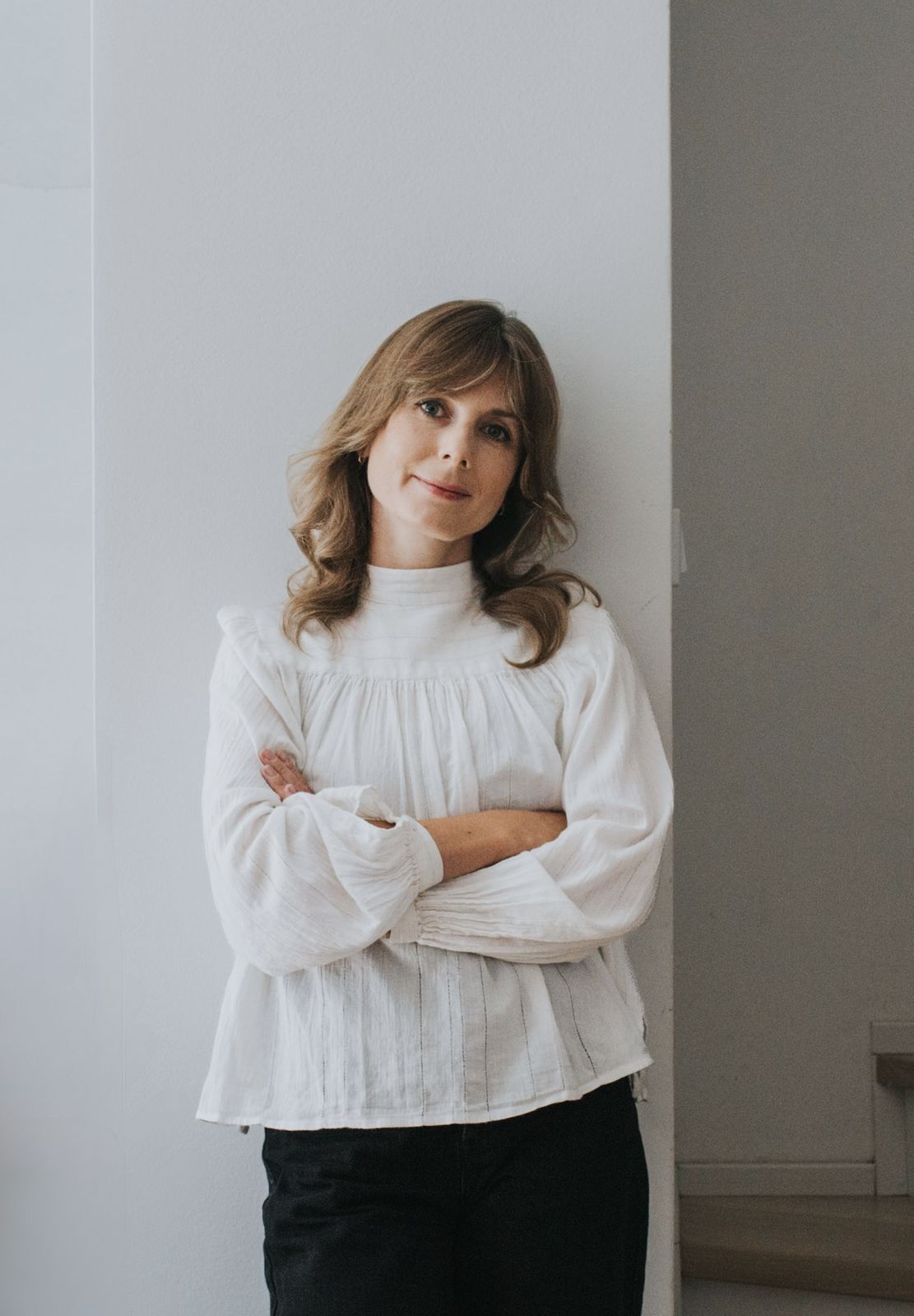 Hanna Wojtaszek-Mikulska w jasnej bluzce, oparta o ścianę